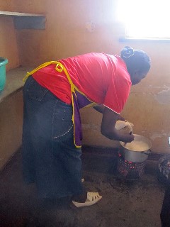 ザンビア人の主食、シマをつくっているお母さん。料理時の姿勢も腰を大きく曲げています。