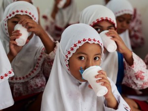 地元で搾乳・加工された牛乳を飲む小学校の子ども達。子どもたちは週に3日の牛乳配布の日が楽しみ。この日は農作業を手伝わせず学校に行かせる親御さんも多いとか。