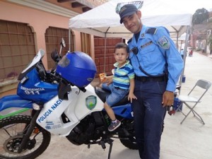 地域警察官のバイクに乗せてもらう地域の子ども