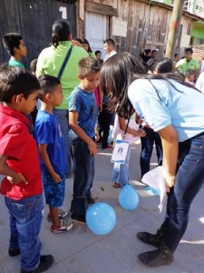 子どもたちに風船割りゲームの説明をするコミュニティリーダー