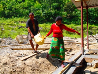 床下に敷く小石を運んでいる村の人たち
