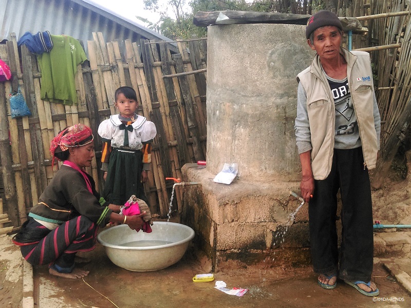 ルウェサン村の村長Aik Siさんと、村人が自発的に建設した貯水槽を使用する住民