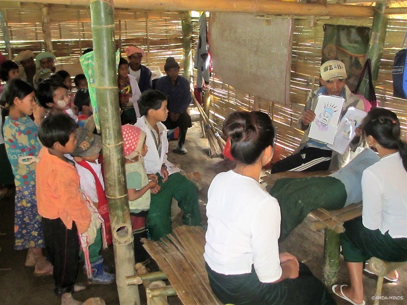 住民手作りの学校で、児童に保健衛生教育を実施する村人と教員